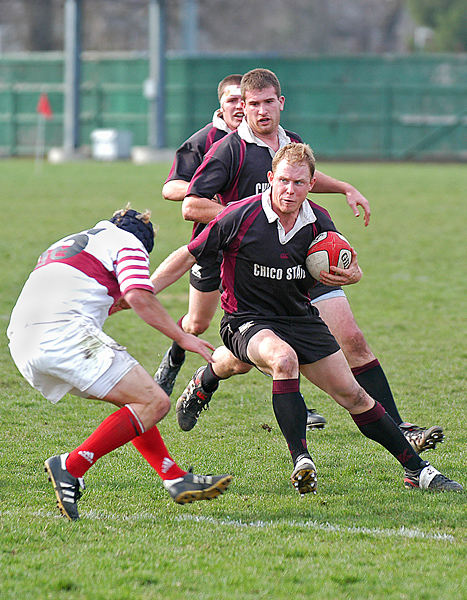 Rugby player juking defender, looking to the left.