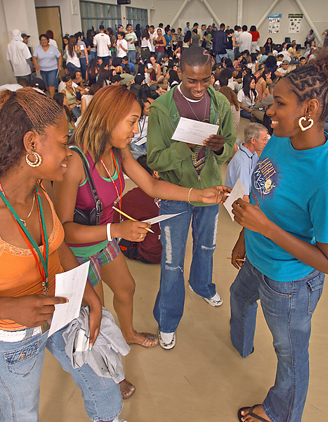 Three EOP students (on the left) get assistance from a peer (on the right) in an EOP orientation program.