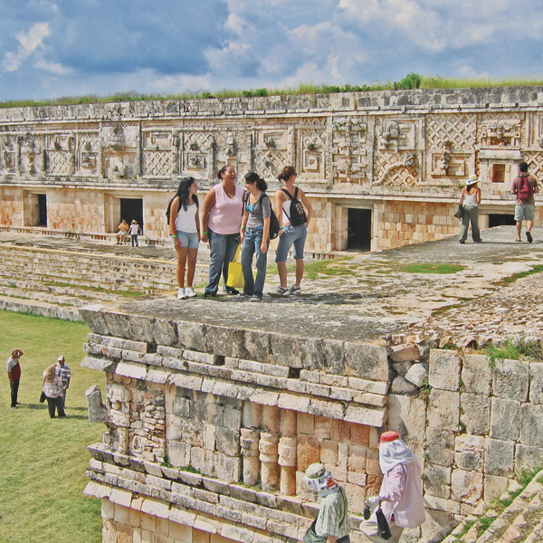 A group of four women stand together atop the ruins of an ancient civilization.