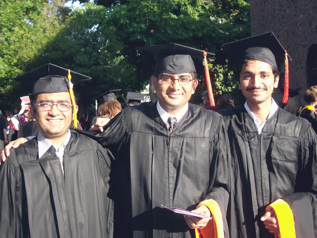 Three graduates pose together following graduation ceremony.