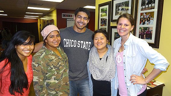 Four women smile, stand on either side of man inside the Cross-Cultural Leadership Center.  Man wears a "Chico State" t-shirt.  
