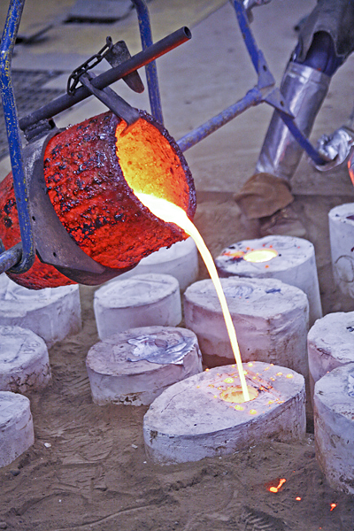 Molten metal is being poured into a receptacle. 