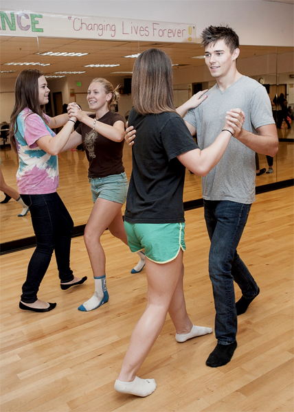 Motion is captured as couples move in unison in a dance class or competition taking place in Acker Gymnasium.