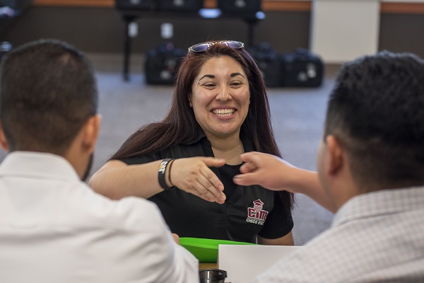 A female student reaches out to shake the hands of a male recruiter during an interview.